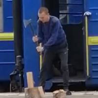 “Ось воно 21 століття”: у мережі показали, як провідник Укрзалізниці рубає дрова прямо на пероні (відео)